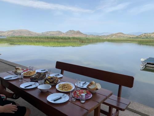 波德戈里察Lake Skadar Paradise的水体旁的桌子上放着食物