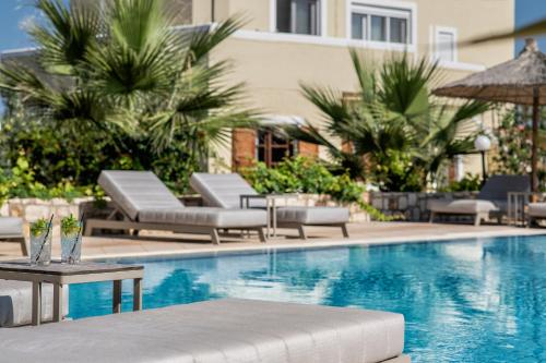 古瓦伊Elea Suites & Residences的一个带躺椅的游泳池和一间酒店