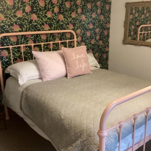 勒兰蒂德威尔斯Self contained apartment的床上有粉红色枕头