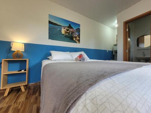费尔南多 - 迪诺罗尼亚Batera House Noronha的一间卧室设有一张蓝色墙壁的大床