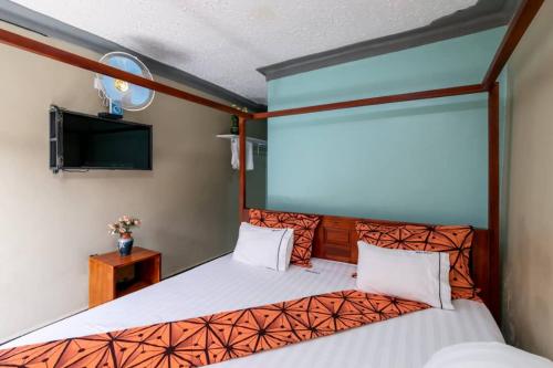 恩德培Haber Motel Enterprise Ltd的一间卧室配有一张床和一台平面电视