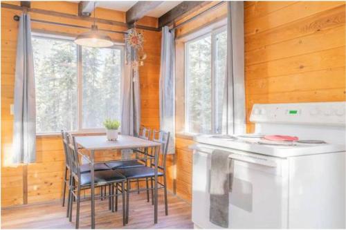 费尔班克斯A Cabin You Won't Want to Leave的厨房配有桌子、桌子和炉灶。