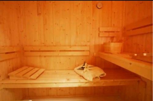 大莫尔文Spring Gardens Retreat And Spa Private hottub,Sauna,Massage的木质桑拿浴室,地板上放着一头牛
