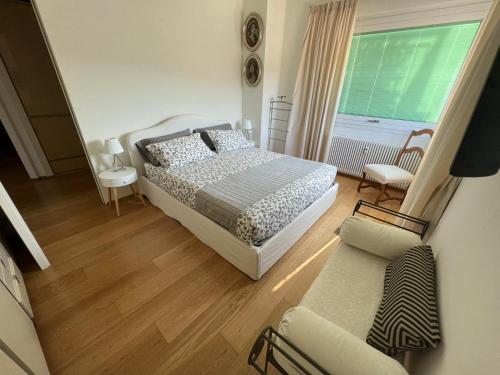 热那亚Casa Amina的一间卧室配有一张床、一张沙发和一个窗口