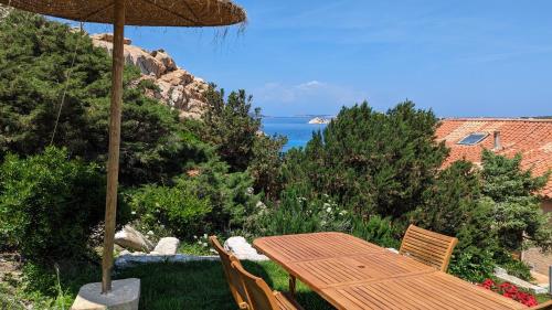 马达莱纳Residence Cala Francese - Case sul mare的一张木桌和椅子,享有海景