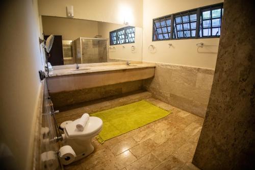 乌贝拉巴Paineiras Hotel Fazenda的带浴缸和卫生间的浴室以及黄色地毯。