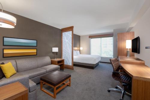 圣何塞Hyatt Place San Jose Airport的酒店客房设有一张沙发和一张床