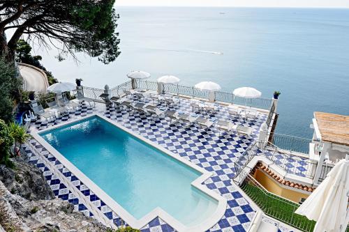 马奥莱潘多拉别墅酒店的一个带椅子的游泳池,背景是大海