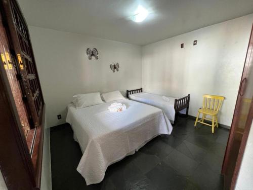圣若热岛POUSADA PALIPALAN的一间卧室配有两张床和一张黄色椅子