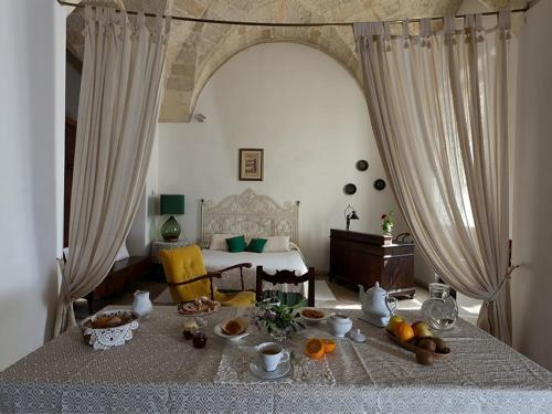 莱切B&b l'Orangerie D'epoque的一间设有一张床铺的房间,配有一张桌子和食物