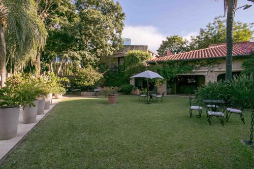 亚松森拉斯洛马斯卡萨酒店的一个带桌椅和雨伞的庭院
