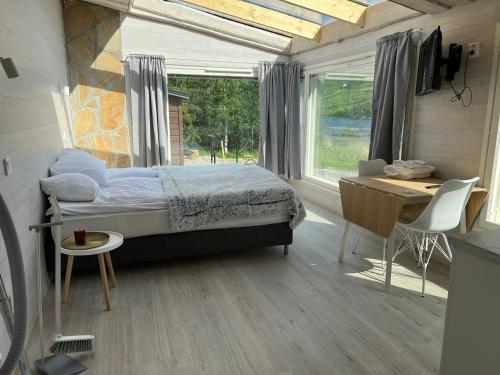 耶姆赛Himosranta Suite with sauna的一间卧室配有一张床、一张书桌和一个窗户。