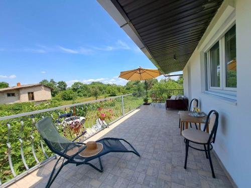 柳布什基Guest house Green River的庭院配有桌椅和遮阳伞。