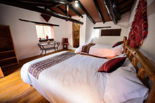 皮萨克Rumi Lodge Pisac的一间卧室配有两张床和一张桌子