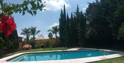 圣胡安特奥蒂瓦坎特奥蒂奥铃酒店的一座带树木和围栏的庭院内的游泳池