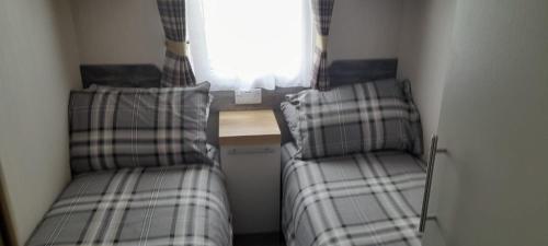 爱丁堡Luxury spacious family caravan的小型客房 - 带2张床和窗户