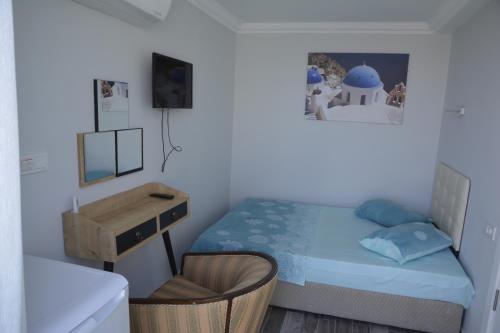 艾瓦勒克Ege Apart & Hotel的一间小卧室,配有一张床和一张书桌