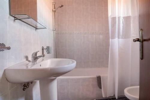 卡尔达斯达·赖尼亚Casa do Moleiro的浴室配有水槽、淋浴和浴缸。