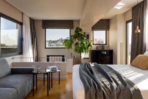 雅典L'Avventura Athens的一间卧室配有一张床、一张沙发和窗户。