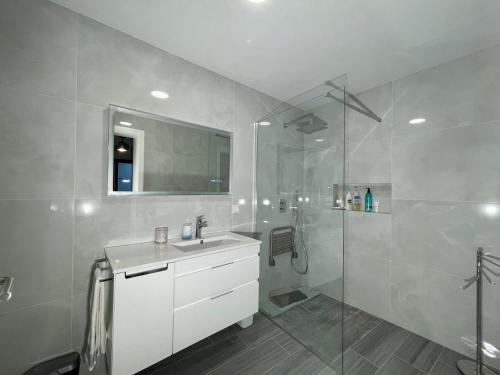 滨海保尔Ocean Front的带淋浴、盥洗盆和镜子的浴室
