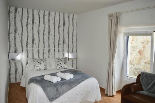 穆罗斯Apartamento Linde的一间卧室配有一张床,上面有两条毛巾