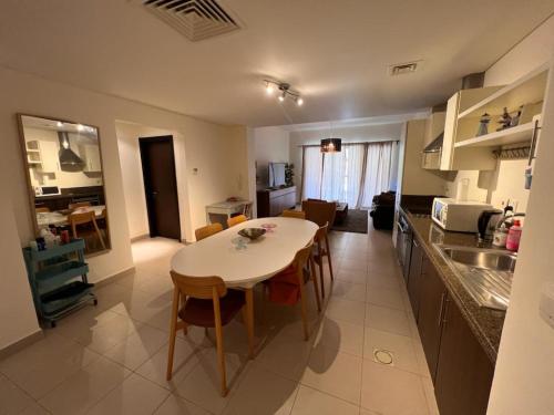 索瓦马Apartment at Samarah Dead Sea Resort的厨房以及带桌椅的起居室。