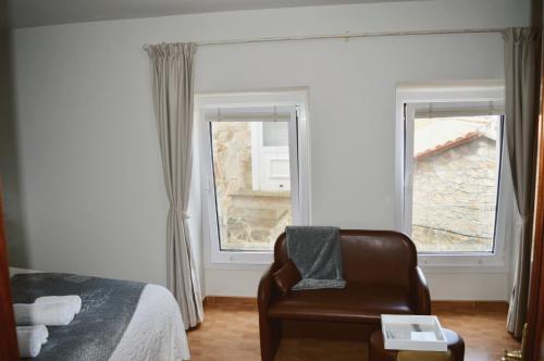 穆罗斯Apartamento Linde的卧室配有床、椅子和窗户。