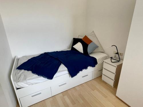 Fürstner Haus的一间卧室配有一张带蓝色床单的床和床头柜。