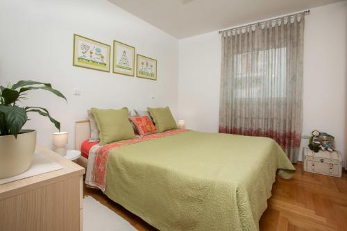 普拉Apartman Toya的一间卧室配有一张床和盆栽植物