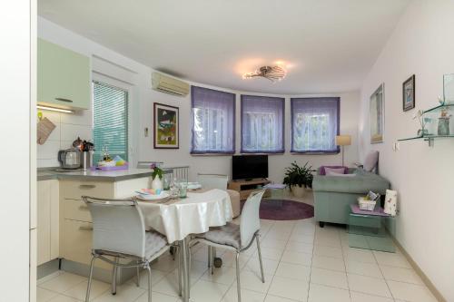 普拉Apartman Toya的厨房以及带桌椅的起居室。