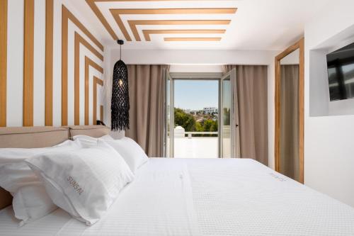 纳乌萨SunSal Luxury Studios - Sky的卧室配有白色的床和窗户。