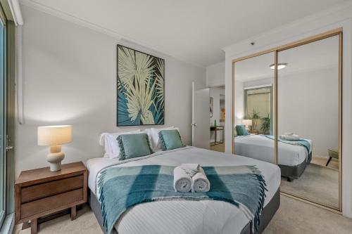 墨尔本Exclusive Stays - Southbank Tower的一间卧室配有一张床,上面有两条毛巾