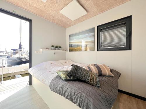 MaasbommelJopies Houseboat的一间卧室设有一张床和一个大窗户