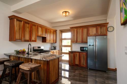 珀拉什奇亚Sandy Feet Beach Resort的厨房配有木制橱柜和不锈钢冰箱。