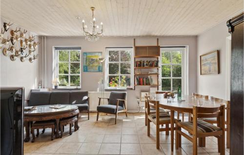 StenstrupAwesome Home In Stenstrup With Wifi的用餐室以及带桌椅的起居室。
