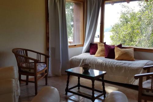 拉安戈斯图拉镇Casa de montaña con vistas al lago y a los cerros的带沙发和窗户的客厅