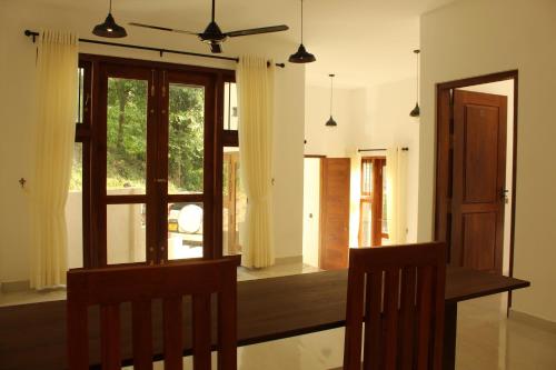 康提Kandy Lotus House的一间带桌子和窗户的用餐室