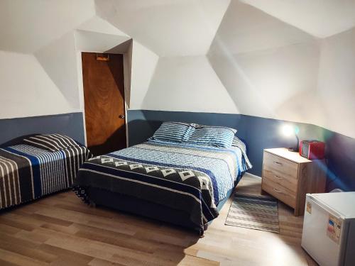 巴伊亚英格莱萨DOMO CAMPING的一间卧室设有两张床,铺有木地板