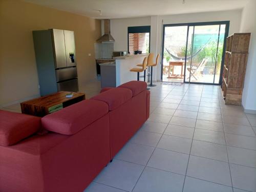 卡宴Beau T3 proche plage secteur Montabo à Cayenne的一间带红色沙发的客厅和一间厨房