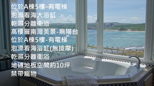 南湾南灣飯店 Kenting Nanwan Hotel的窗户前设有带浴缸的浴室