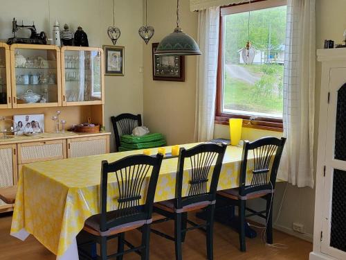 SpildraHoliday home Reinfjord的餐桌、椅子和黄色桌布