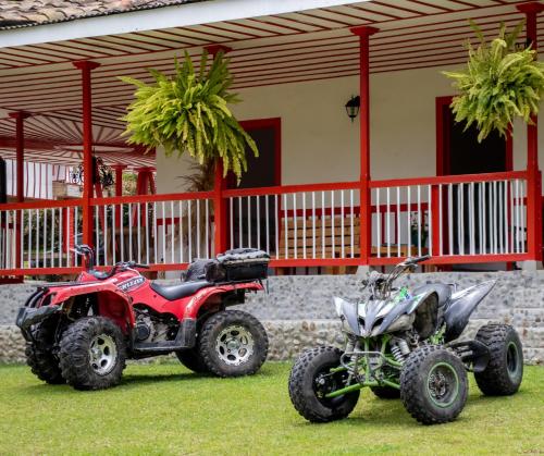 圣罗莎德卡瓦尔Hotel Rural SAN REMO的两公尺和一辆四轮摩托车停在房子前面