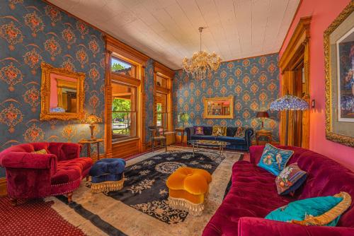 普韦布洛Orman Mansion - Pueblo's Most Luxurious Stay!的客厅设有红色沙发和蓝色的墙壁