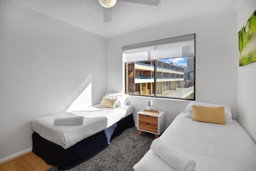 安特兰斯艾威拉苑2号公寓的一间卧室设有两张床和窗户。