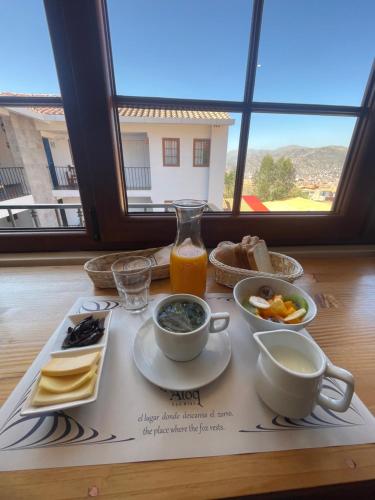 库斯科Atoq San Blas Hotel的一张桌子,上面放着一盘食物和一杯橙汁