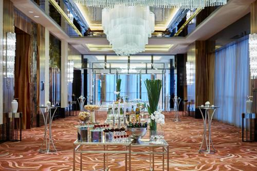 株洲株洲美的万豪酒店的大堂设有一张桌子和瓶装葡萄酒