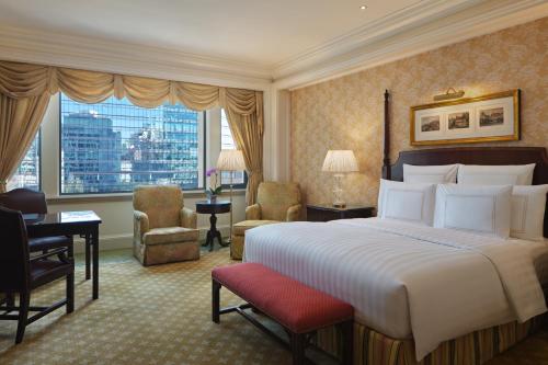北京北京丽思卡尔顿酒店的酒店客房,配有一张床、一张桌子和椅子
