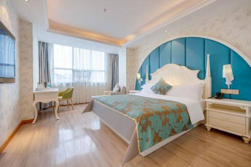 郴州莫林酒店郴州火车站店的酒店客房设有一张大床和一张书桌。