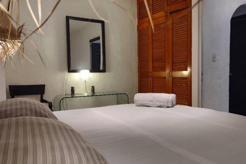 坎昆Casa de Cielo y Mar en Cancún的一间卧室配有一张床、一张桌子和一面镜子
