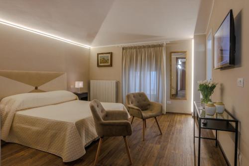 蒙特卡蒂尼泰尔梅阿拉西奥酒店的一间卧室配有一张床和两把椅子